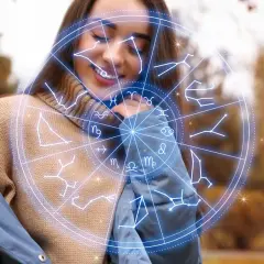 Uśmiechnięta kobieta w swetrze i kurtce, otoczona przez koło zodiaku. Numerologia 11 i 11.