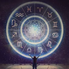 Osoba z rękami w górze przed kołem zodiaku, gdzie widnieje najsilniejszy znak zodiaku.