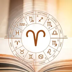 Koło zodiaku z symbolem Barana, uważanego za najbardziej agresywny znak zodiaku, na tle otwartej księgi.