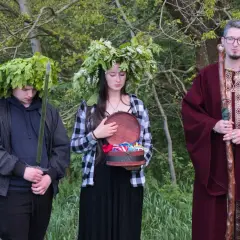 U starożytnych Celtów druid w bordowej szacie z laską, młody mężczyzna z mieczem i w wieńcu z liści dębu, oraz dziewczyna z wieńcem z kwiatów i otwartą szkatułką.