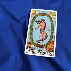 Karta **the world tarot** przedstawia nagą postać w tańcu, otoczoną wieńcem i symbolami czterech ewangelistów.
