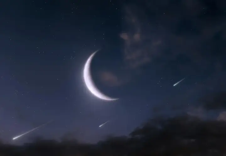 Nocne niebo z jasnym, sierpowatym księżycem w Bliznietach i spadającymi gwiazdami.