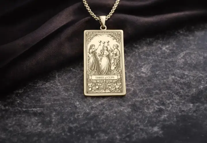 Złoty wisiorek z motywem 3 puchary tarot. Trzy kobiety wznoszą kielichy, celebrując radość i wspólnotę.