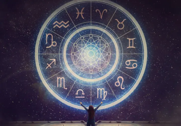 Osoba z rękami w górze przed kołem zodiaku, gdzie widnieje najsilniejszy znak zodiaku.