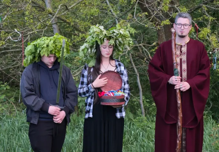 U starożytnych Celtów druid w bordowej szacie z laską, młody mężczyzna z mieczem i w wieńcu z liści dębu, oraz dziewczyna z wieńcem z kwiatów i otwartą szkatułką.