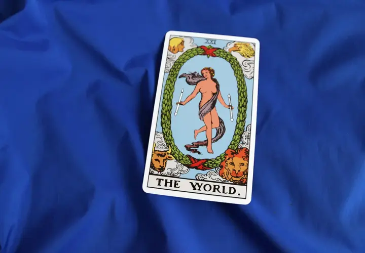 Karta **the world tarot** przedstawia nagą postać w tańcu, otoczoną wieńcem i symbolami czterech ewangelistów.