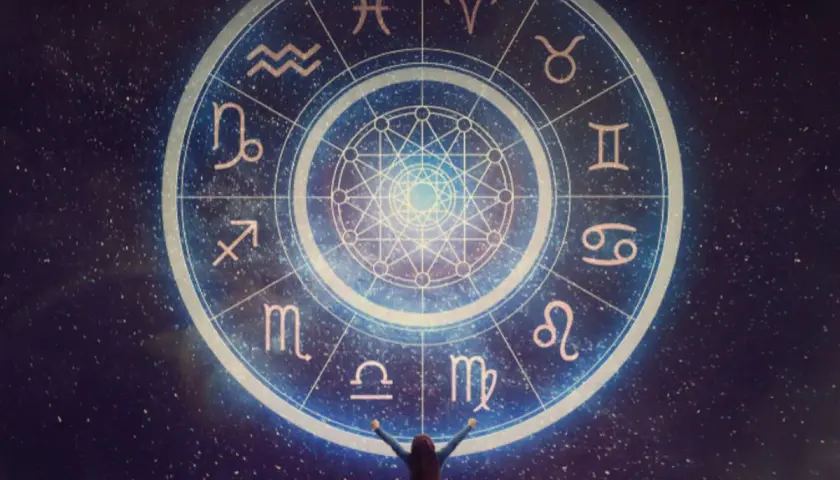 Osoba z rękami w górze przed kołem zodiaku, gdzie widnieje najsilniejszy znak zodiaku.