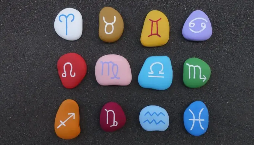 Kolorowe kamienie z symbolami zodiaku ułożone w rzędach. Sprawdź zgodność znaków zodiaku!