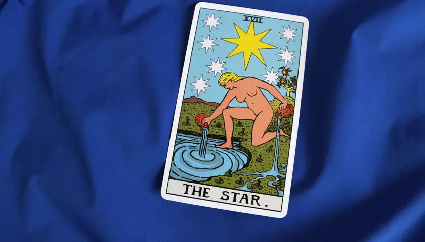 Karta Gwiazda Tarot symbolizuje nadzieję i spokój w uczuciach. Kobieta wylewa wodę, odnawiając życie.