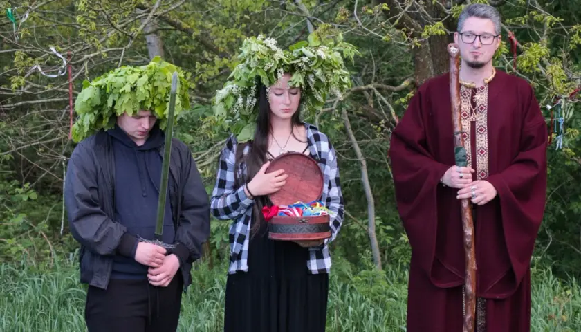 U starożytnych Celtów druid w bordowej szacie z laską, młody mężczyzna z mieczem i w wieńcu z liści dębu, oraz dziewczyna z wieńcem z kwiatów i otwartą szkatułką.