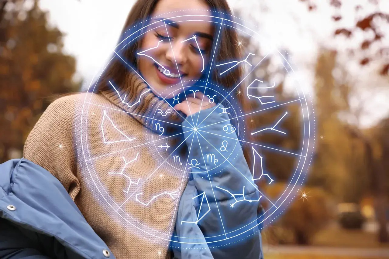Uśmiechnięta kobieta w swetrze i kurtce, otoczona przez koło zodiaku. Numerologia 11 i 11.