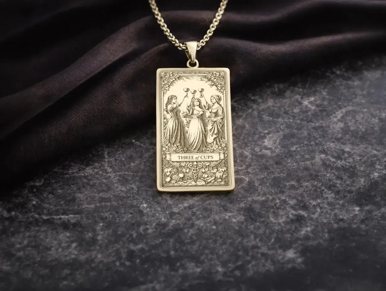 Złoty wisiorek z motywem 3 puchary tarot. Trzy kobiety wznoszą kielichy, celebrując radość i wspólnotę.
