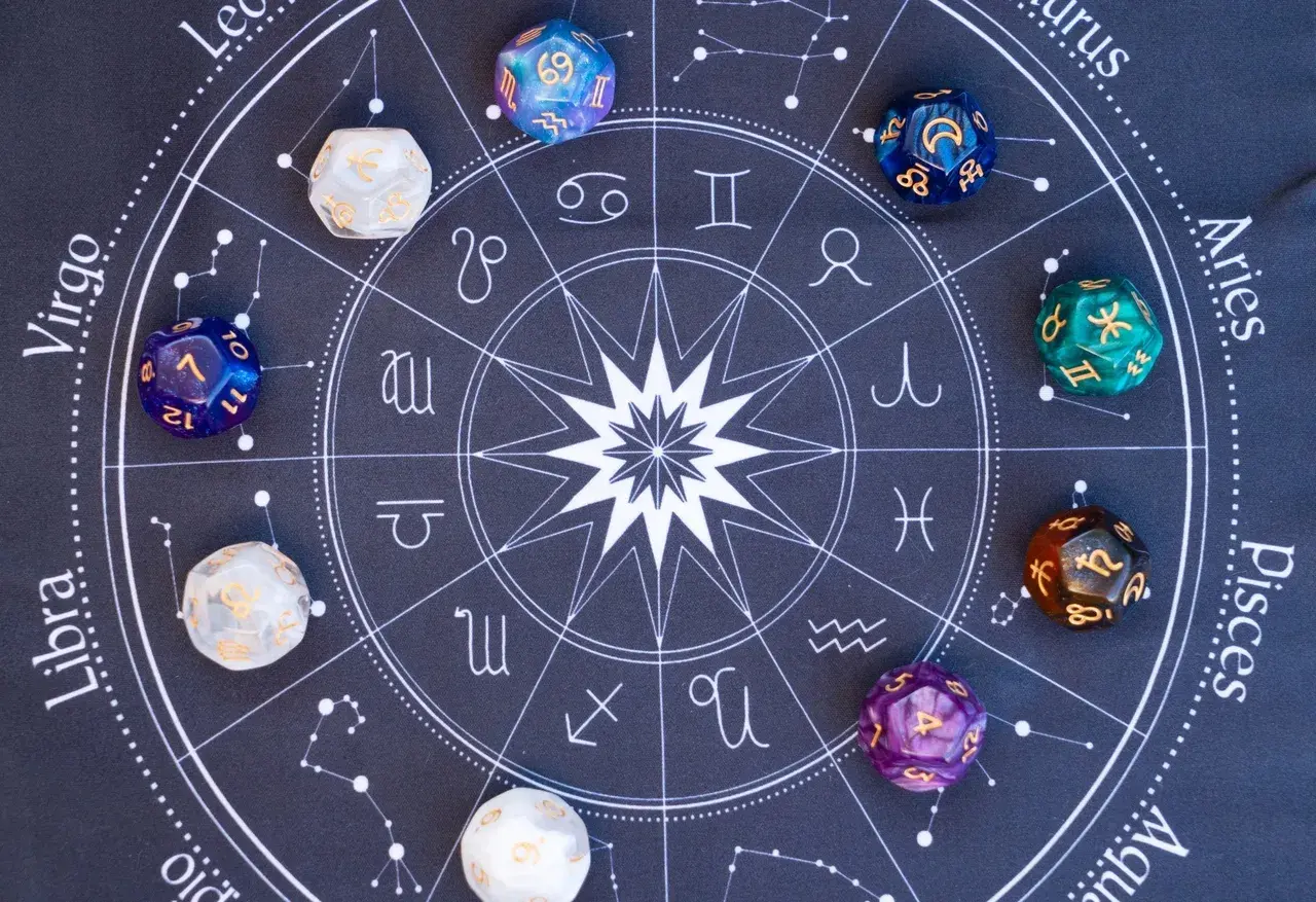 Na tle koła zodiaku leżą kolorowe kostki z liczbami. Czy to liczby mistrzowskie, które odkrywają tajemnice stare dusze?