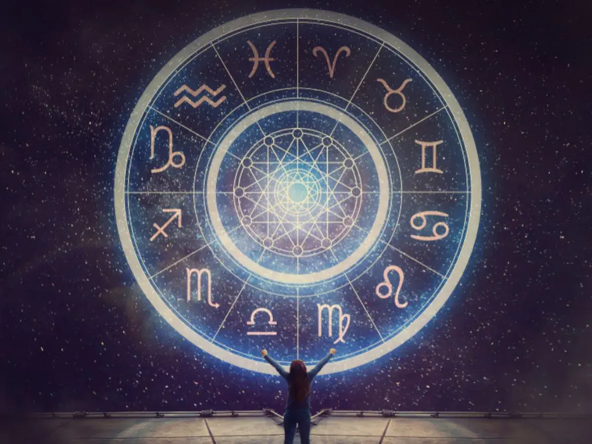 Osoba z rękami w górze przed kołem zodiaku, gdzie widnieje najsilniejszy znak zodiaku.