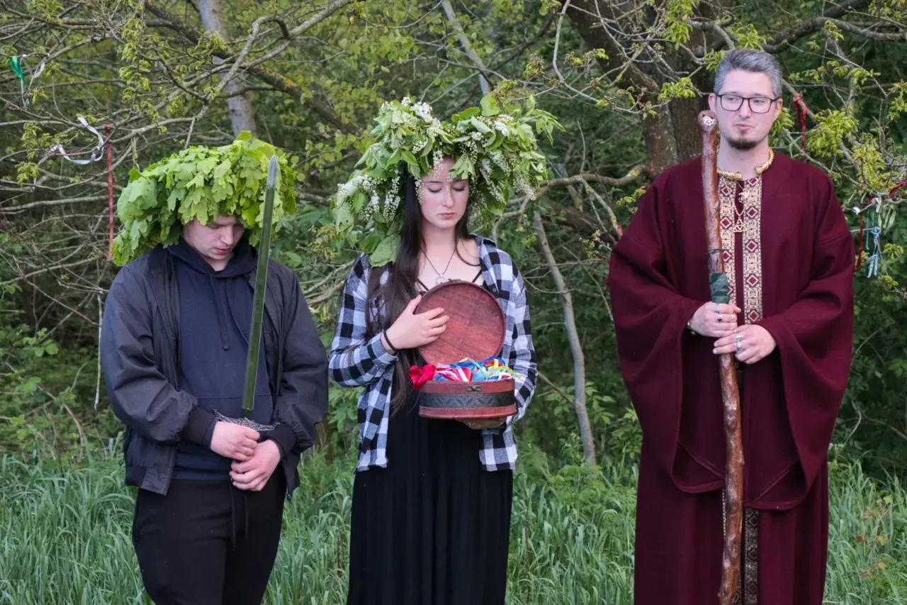 U starożytnych Celtów druid w bordowej szacie z laską, młody mężczyzna z mieczem i w wieńcu z liści dębu, oraz dziewczyna z wieńcem z kwiatów i otwartą szkatułką.