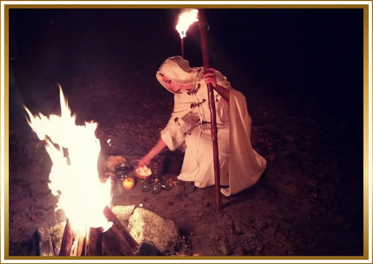 Nocny rytuał. Druid u starożytnych Celt&oacute;w, w białej szacie, z pochodnią, przy ognisku odprawia magiczne obrzędy.